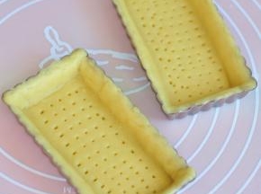 把派皮擀开，盖到模具上，去掉多余的部分，稍做整形，使派皮与模具服帖。然后用叉子叉上眼洞。