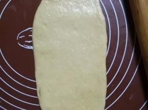.取一块面团擀成牛舌状，卷起来，再擀成牛舌状，再卷起来。