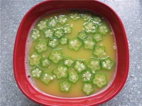 将切成片的秋葵放入蛋液中