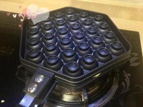 7、盖上模具迅速翻面，面糊会溢出少许，不需理。小火加热，一面大约1-2分钟左右。