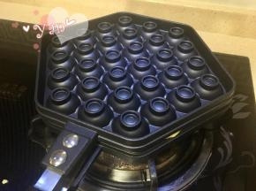 7、盖上模具迅速翻面，面糊会溢出少许，不需理。小火加热，一面大约1-2分钟左右。