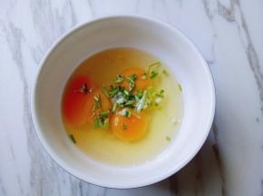 鸡蛋打在碗里，加入切碎的葱花。