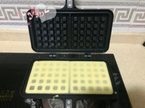 7、熄火，放平模具，倒入华夫饼液，用刮刀适当刮平。不要倒太多看不到下面的格子，液体适当高出一点即可。