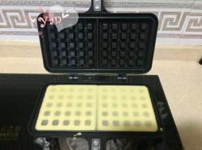 7、熄火，放平模具，倒入华夫饼液，用刮刀适当刮平。不要倒太多看不到下面的格子，液体适当高出一点即可。
