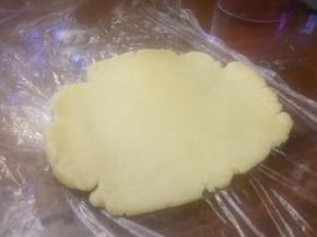 铺好保鲜膜，把饼皮，擀成圆形；