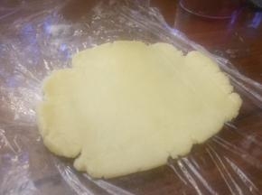 铺好保鲜膜，把饼皮，擀成圆形；