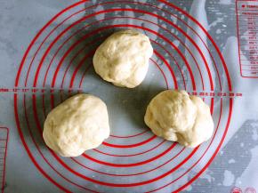 取出面团揉圆按扁排气，分成三等份，盖保鲜膜松弛10分钟。