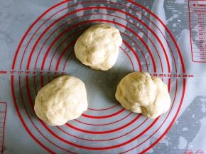 取出面团揉圆按扁排气，分成三等份，盖保鲜膜松弛10分钟。