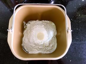 所有面包材料放入面包内桶，先放液体，牛奶、蛋液（预留一点点）、加拿大芥花油。然后左角放盐，右角放糖。最后放高粉，在高粉上挖个坑埋入酵母。