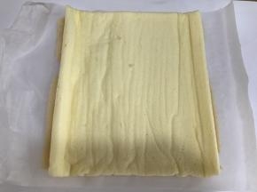 将蛋糕卷平铺，均匀的抹上一层奶油