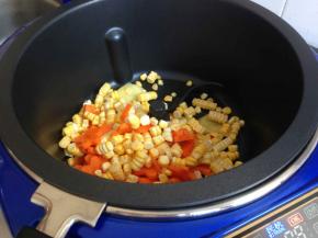 炒菜机加热后，选择炒菜功能，时间八分钟，锅里加油，放入玉米胡萝卜。