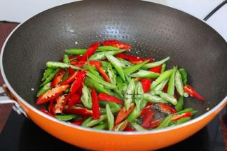 热锅，倒油，放入红辣椒、青辣椒爆炒八成熟；
