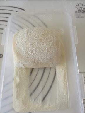 卷好的面团在奶粉中滚一圈