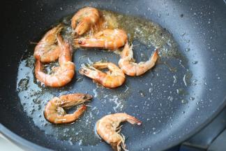 炒锅下油，油热后下入虾煎香两面。