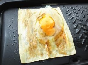 冷面上均匀刷上一层酱，磕一个鸡蛋在冷面上。