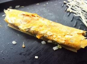 借助铲子和烧烤夹把冷面卷起来。