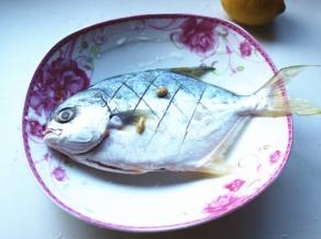 擦干鱼身上水分，两面打花刀，挤上半个柠檬的汁，撒少许盐，抹匀了腌制一夜。