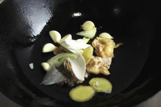 鸡皮略微煸出一些油，再加适量花生油，爆香姜片葱段和蒜。