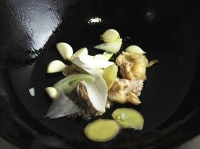 鸡皮略微煸出一些油，再加适量花生油，爆香姜片葱段和蒜。