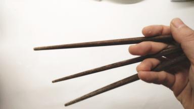 准备3根筷子，如图所示握住，使筷子形成一个三角形。