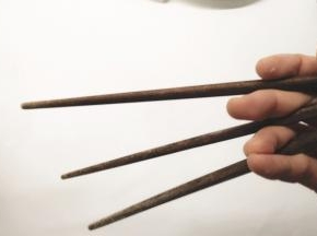 准备3根筷子，如图所示握住，使筷子形成一个三角形。