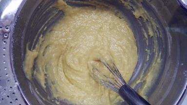 筛入低筋面粉、杏仁粉和泡打粉，用手动打蛋器将它们翻拌均匀。