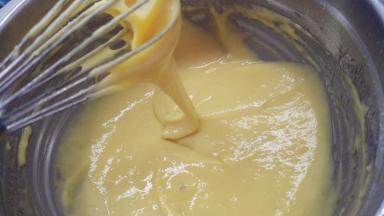 黄油隔水加热融化，分两次加入到面糊中，翻拌均匀。