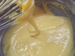 黄油隔水加热融化，分两次加入到面糊中，翻拌均匀。