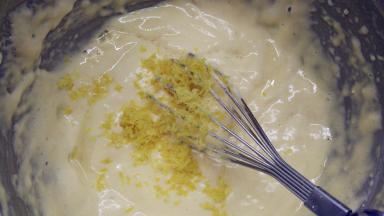 把柠檬皮屑和柠檬汁全部倒进去。用手动打蛋器快速将它们搅拌均匀，记得速度要快。