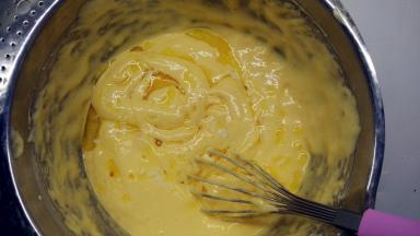 融化的黄油通过打蛋器淋在面糊表面，记得分散一些，继续用手动打蛋器翻拌均匀。