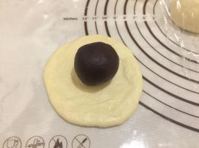 将面团擀成薄片，红豆沙放在面团上