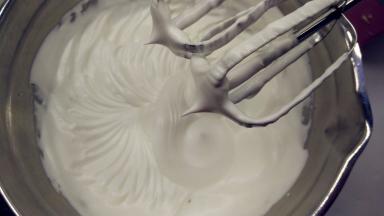 往蛋白中分3次加入糖粉，打至干性发泡。（首先，用打蛋器低速将蛋白搅打至起鱼眼泡，加入1/3的糖粉。接着，继续用电动打蛋器高速搅打，至蛋白体积膨胀1倍，再加入1/3的糖粉。然后，继续用电动打蛋器中速搅打，稍微出现纹路，加入剩余的1/3的糖粉。最后低速搅打，直至明显感到阻力，提起打蛋器时尖端是短而小的尖峰即可。）