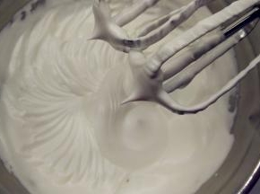 往蛋白中分3次加入糖粉，打至干性发泡。（首先，用打蛋器低速将蛋白搅打至起鱼眼泡，加入1/3的糖粉。接着，继续用电动打蛋器高速搅打，至蛋白体积膨胀1倍，再加入1/3的糖粉。然后，继续用电动打蛋器中速搅打，稍微出现纹路，加入剩余的1/3的糖粉。最后低速搅打，直至明显感到阻力，提起打蛋器时尖端是短而小的尖峰即可。）