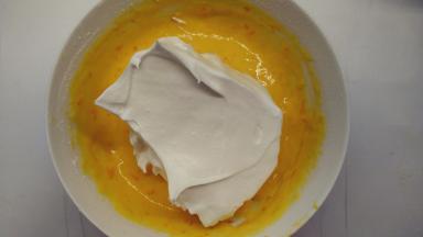 取1/3的蛋白霜加入到蛋黄糊中，用橡皮刮刀用翻拌的手法拌匀。