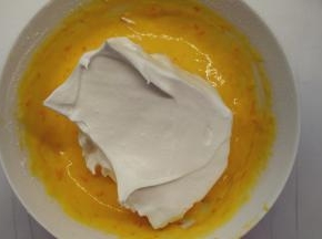 取1/3的蛋白霜加入到蛋黄糊中，用橡皮刮刀用翻拌的手法拌匀。