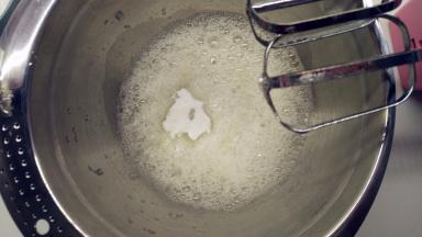 往蛋白中分3次加入糖粉，打至湿性发泡。（首先，用打蛋器低速将蛋白搅打至起鱼眼泡，加入1/3的糖粉。接着，继续用电动打蛋器高速搅打，至蛋白体积膨胀1倍，再加入1/3的糖粉。然后，继续用电动打蛋器中速搅打，稍微出现纹路，加入剩余的1/3的糖粉。最后低速搅打，直到提起打蛋器时出现鹰钩嘴即可。）
5取1/3的蛋白霜加入到蛋黄糊中，用橡皮刮刀用翻拌的手法拌匀。