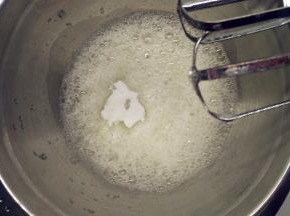 往蛋白中分3次加入糖粉，打至湿性发泡。（首先，用打蛋器低速将蛋白搅打至起鱼眼泡，加入1/3的糖粉。接着，继续用电动打蛋器高速搅打，至蛋白体积膨胀1倍，再加入1/3的糖粉。然后，继续用电动打蛋器中速搅打，稍微出现纹路，加入剩余的1/3的糖粉。最后低速搅打，直到提起打蛋器时出现鹰钩嘴即可。）
5取1/3的蛋白霜加入到蛋黄糊中，用橡皮刮刀用翻拌的手法拌匀。