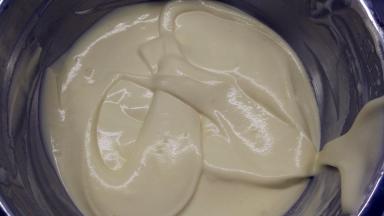 再倒回蛋白霜中，继续用橡皮刮刀用翻拌的手法拌匀，直至看不到一丝蛋白，面糊呈细腻光滑状。之后先分别取出1小勺+2勺面糊，放在两个碗中。