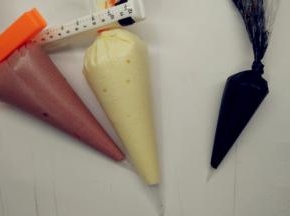 取出刚刚1小勺的原色面糊放在碗中，加入竹炭粉，翻拌均匀，成为黑色面糊。分别将三种颜色的面糊装进裱花袋中。