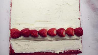 在小山丘上摆上草莓，注意蛋糕卷两头草莓放置的方向。