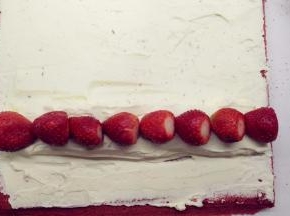 在小山丘上摆上草莓，注意蛋糕卷两头草莓放置的方向。