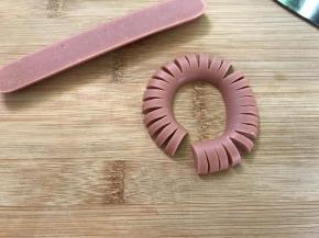 把切开的一半火腿肠的外侧切开，不要全部切断。