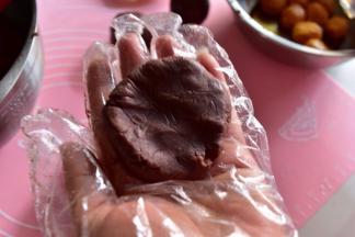 将豆沙分成30份，搓圆压扁平摊手中