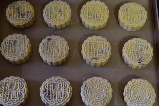 100g模具内撒适量干粉防粘，将月饼球放入模具中拍平压实，然后轻推在烤盘上