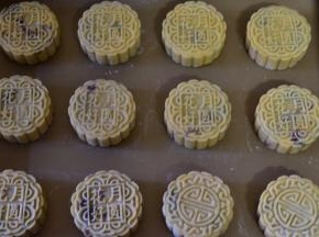 100g模具内撒适量干粉防粘，将月饼球放入模具中拍平压实，然后轻推在烤盘上