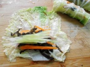 取白菜叶铺开，放上莴笋丝、胡萝卜丝、木耳和培根
