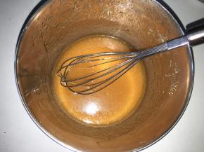 转化糖浆倒入碗里，加入枧水、花生油用手动打蛋器搅拌均匀