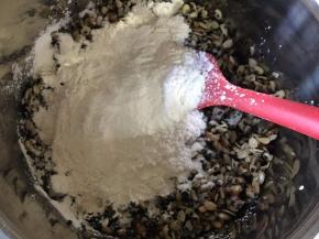 把放凉待用的坚果、桔饼、冬瓜糖全部放入大碗混合均匀，加入细砂糖、白酒、食用油、水、熟糯米粉搅拌均匀成团