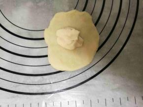 取一份水油皮擀开包住一份油酥后搓圆