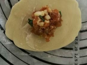 擀开后包住15克馅料，收口向下搓圆